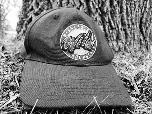 A hat sitting in the grass in front of a tree.