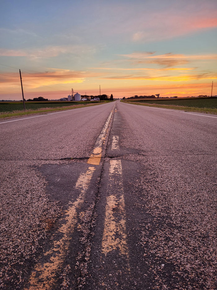 A picture of a road up close during a sunset.